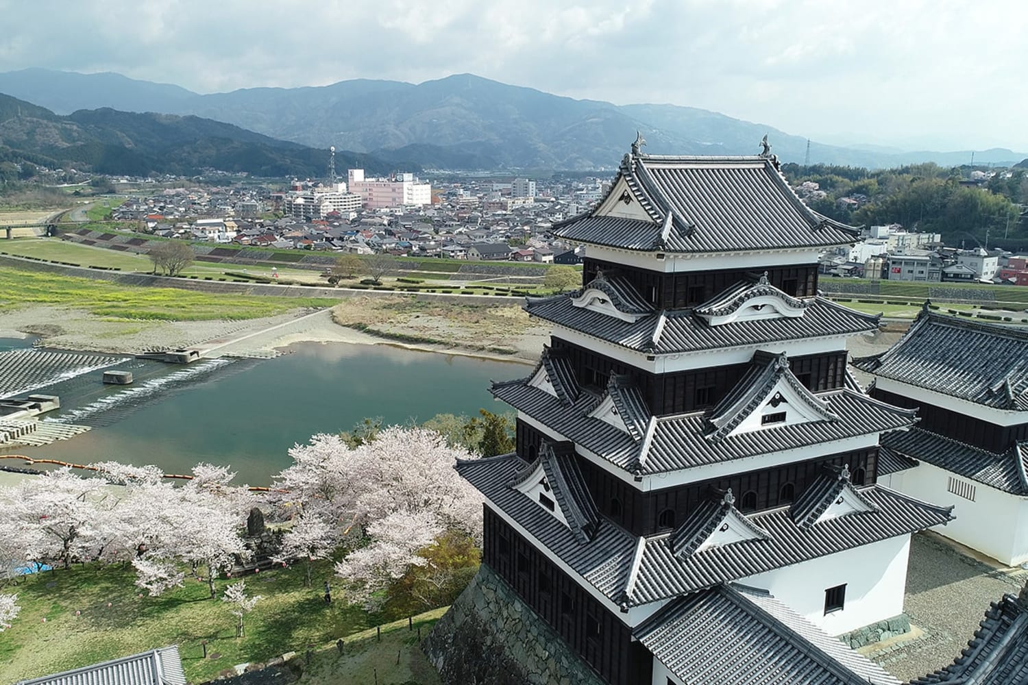 Ozu Castle keep rising above the Hiji River at dusk